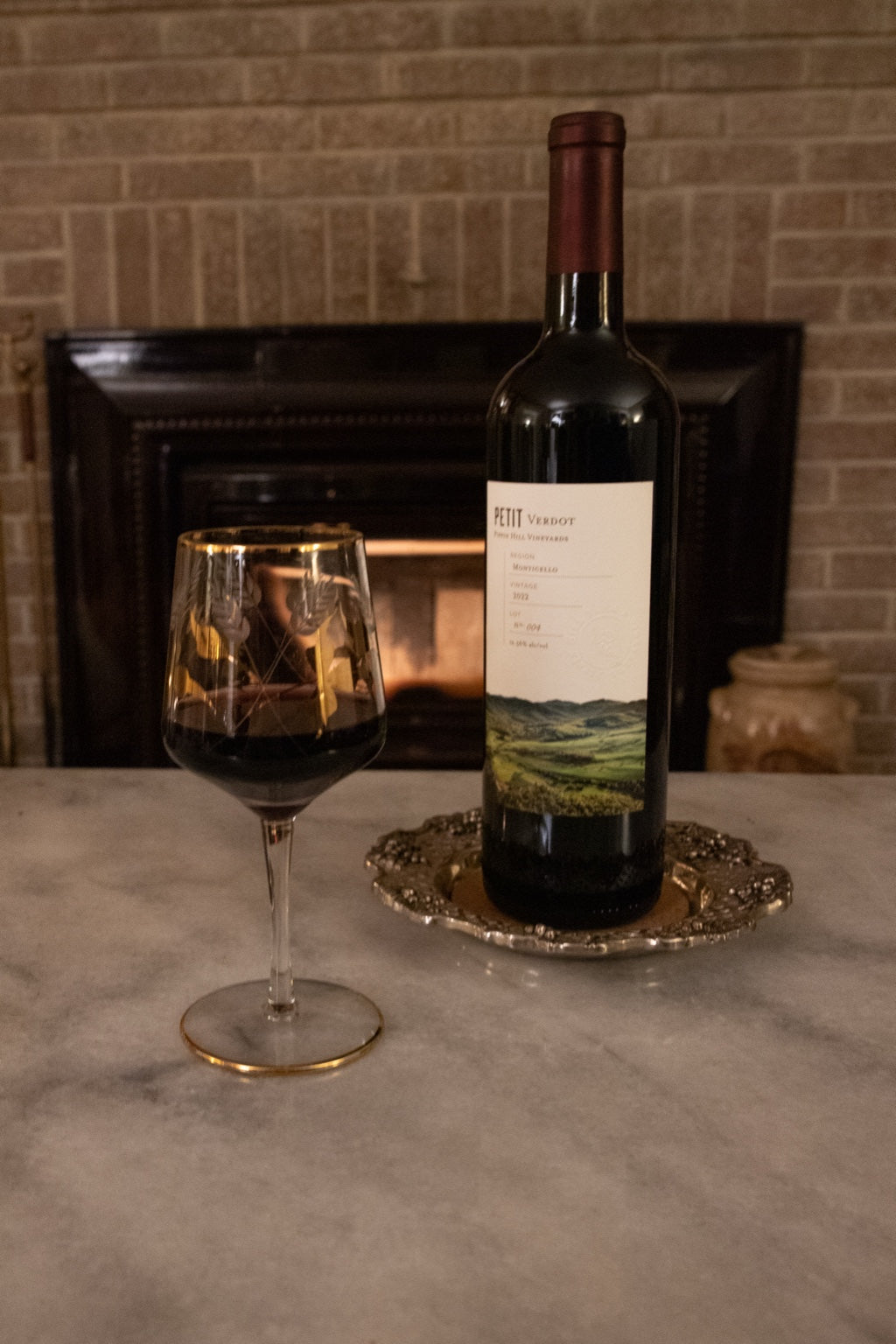 Vintage Godinger wine coaster styled with wine by the fireplace