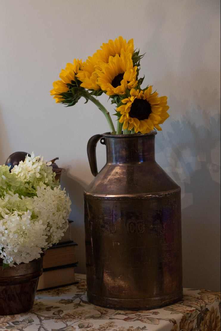 Vintage brass dairy can styled with sunflowers in Harvest in New England